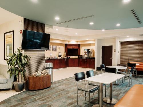 a living room with a tv and a table and chairs at The Beacon Charlotte Airport by IHG in Charlotte