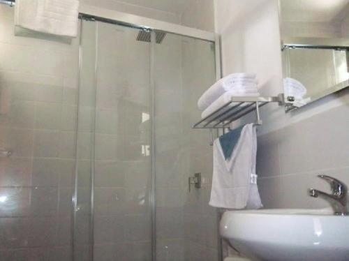a bathroom with a glass shower and a sink at Hotel Casa Ecuatreasures Centro Historico in Quito