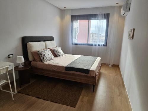 a small bedroom with a bed with a window at Appartement de standing - Emplacement stratégique in Casablanca