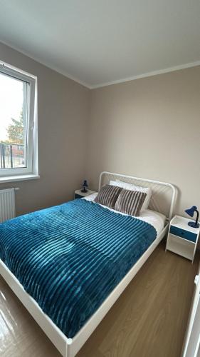 a bedroom with a large bed with a blue blanket at Włocławek Saperska in Włocławek