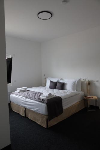 a bedroom with a large bed with white sheets and pillows at nurHotel in Reinbek