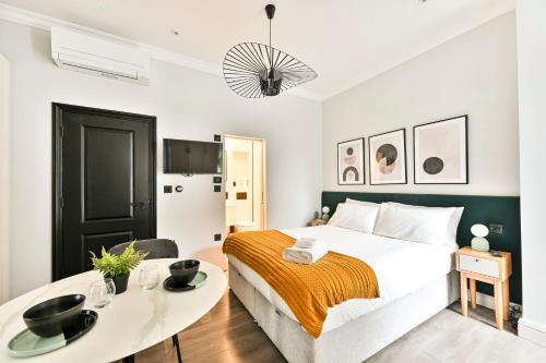 a bedroom with a large bed and a table at The Collection Stays Chelsea in London