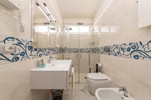 a bathroom with a white sink and a toilet at Riviera Luxury Rooms in Porto Cesareo