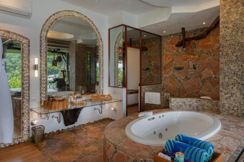 a large bathroom with a tub and a large mirror at Villa Lala Boutique Hotel Adults Only in Puerto Vallarta