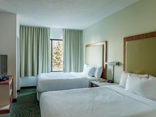 a hotel room with two beds and a window at The Beacon Charlotte Airport by IHG in Charlotte