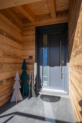a front door of a wooden house with christmas trees at Vigne en Ville in Aosta