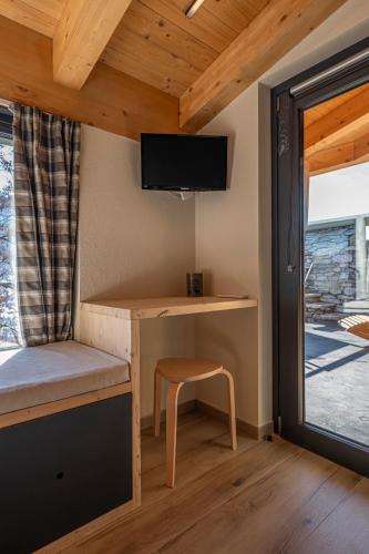 a room with a desk with a chair and a tv at Vigne en Ville in Aosta