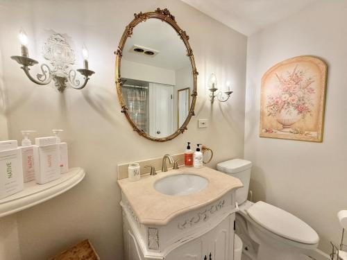 a bathroom with a sink and a mirror and a toilet at Cozy Manhattan View Suite in West New York