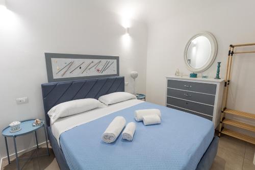 a bedroom with a blue bed with two white towels at LA PERLA in Cefalù