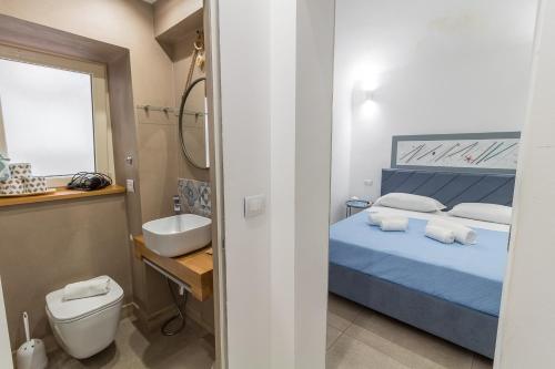 a bathroom with a bed and a sink and a toilet at LA PERLA in Cefalù