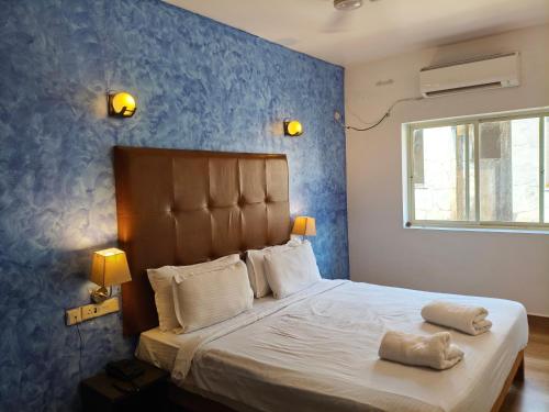 a bedroom with a bed with a blue wall at Dacha by Great Host in Arambol