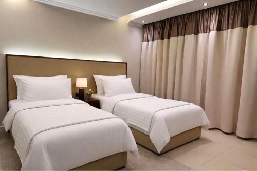two beds sitting next to each other in a bedroom at نزل ارام النفل Nozol Aram 4 in Riyadh