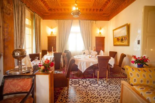 a dining room with a table and some chairs at Villa Pomme d'Or in Midelt