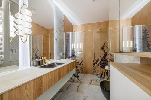 a bathroom with a sink and a mirror at Salamandra Luxury Villas with Jacuzzi by BQQK in Kościelisko