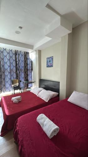 a bedroom with two beds with red sheets and a window at LE dEON HOTEL Former Pine Hotel in Batu Gajah