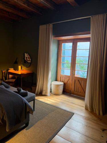 a bedroom with a bed and a large window at Firemasters House Historic Church Street in Tulbagh in Tulbagh