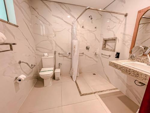 a white bathroom with a toilet and a sink at Principe do Mutá Hotel Design in Santa Cruz Cabrália