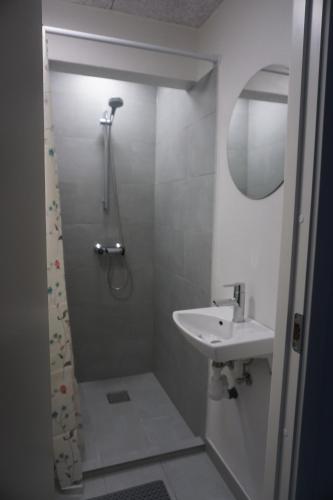 a small bathroom with a shower and a sink at Værelse tæt på strand og by in Hirtshals