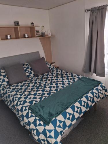 a bedroom with a bed with a blue at Comforts caravan in Winthorpe