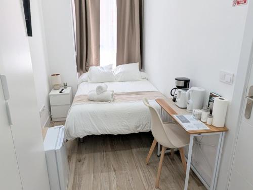 a small bedroom with a bed and a table at Lofts IFEMA CH in Madrid