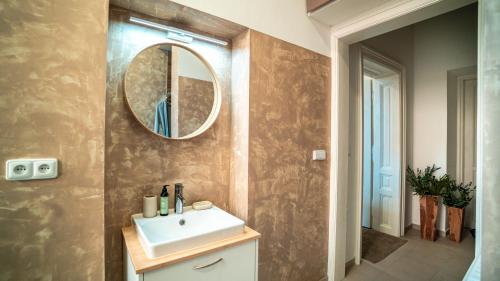a bathroom with a sink and a mirror on the wall at Peony Apartment in Kroměříž
