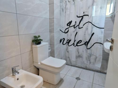a bathroom with a toilet and a shower curtain at Luce Apartment in Shkodër