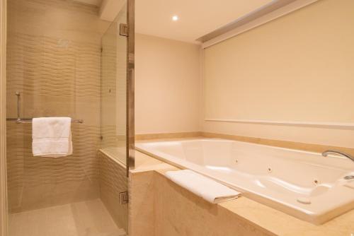 a bathroom with a bath tub and a shower at Royalton Hideaway Punta Cana, An Autograph Collection All-Inclusive Resort & Casino - Adults Only in Punta Cana