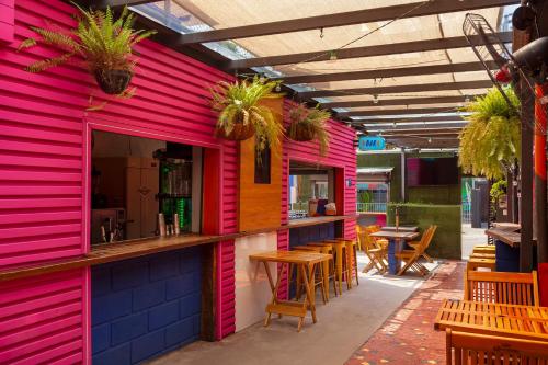 a pink building with a bar and some tables at Ô de Casa Hostel Bar in São Paulo