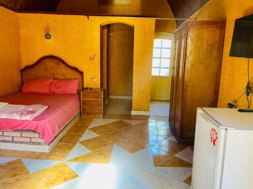 a bedroom with a bed and a tiled floor at Old Oasis Hotel for Safari Trips in Az Zabū