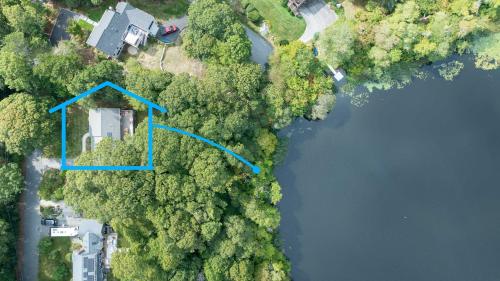 an aerial view of a house in the middle of a lake at Pond Front Home with Private Dock in Brewster