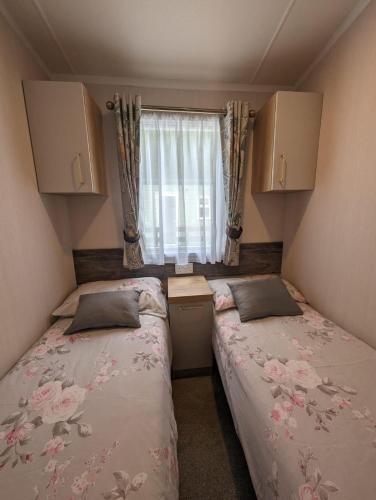 two beds in a small room with a window at Swift Bordaux 68 in Ardentinny