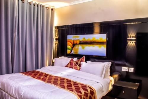 a bedroom with a bed with a tv on the wall at Spring Hills Group in Dodoma