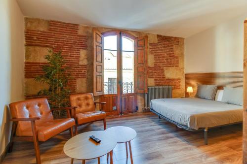 a bedroom with a bed and a chair and a table at MoneoHeritage in Salamanca