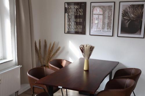 a dining room table with chairs and a vase on it at Boutique Suite Hannah in Bautzen