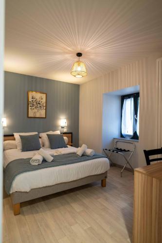 a bedroom with a large bed with a ceiling at Auberge du Cezallier in Montgreleix