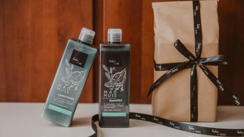 two bottles of hair products and a bag on a table at Ruby Stella Hotel London by IHG in London