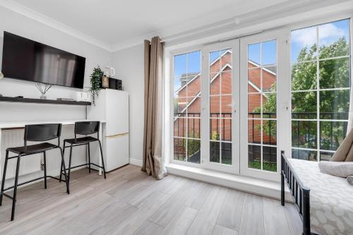 a bedroom with a bed and a kitchen with a counter at Riverview, studio style room near station R3 in London
