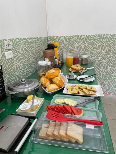a table topped with plates of food and bread at Pousada Pura Vida Bertioga in Bertioga