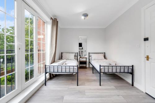 a living room with two beds and large windows at Riverview, studio style room near station R3 in London