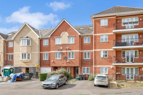 two cars parked in front of a brick building at Riverview, studio style room near station R3 in London