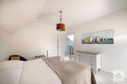 a bedroom with a bed and a painting of sailboats at Ker Lilouane in Hirel