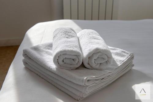 a pile of towels sitting on top of a bed at La Maison de Pêcheurs in Cancale