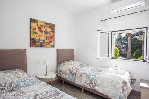 a bedroom with two beds and a window at Filerimos House in Ialysos