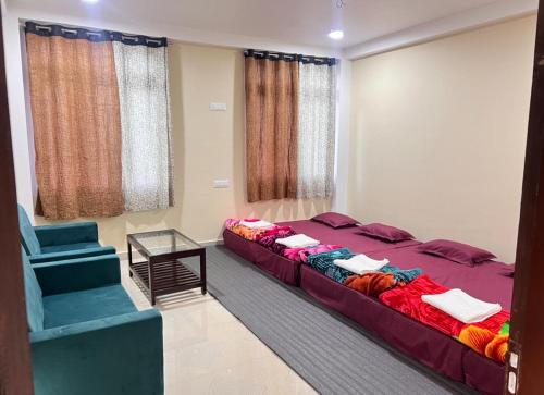a bedroom with a large bed and a blue chair at YNL HOMESTAY a boutique hotel in Dirang Dzong