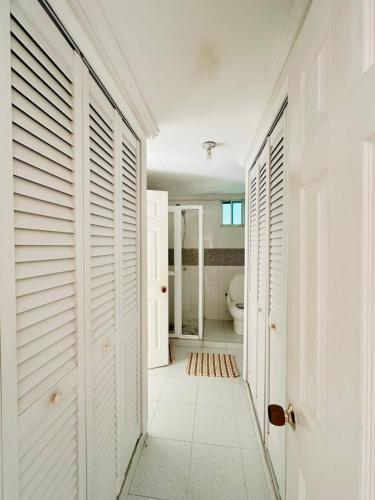 a hallway with white doors and a toilet in a bathroom at Enchanted Paradise in Ayacucho