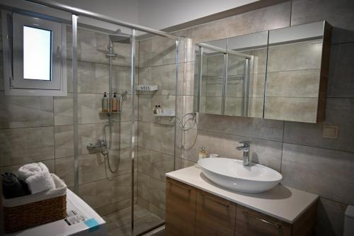 a bathroom with a sink and a glass shower at Thea Hill in Kritharia