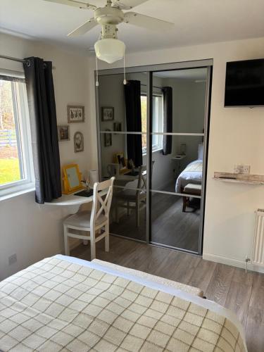 a bedroom with a bed and a desk and a mirror at Craigdarroch Guest House in Contin