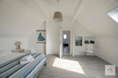 a bedroom with a bed and a table and a chair at La Cabane à Hirel in Hirel