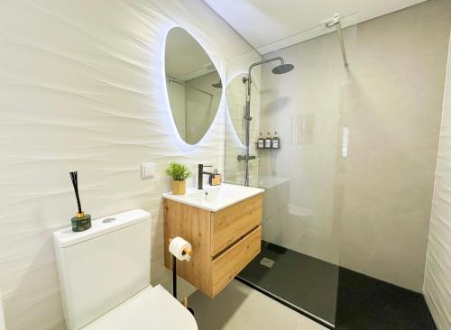 a bathroom with a toilet and a sink and a shower at Ninho da Ribeira in Ribeira Brava