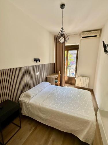 a bedroom with a white bed and a window at Hostal Fernández Atocha in Madrid